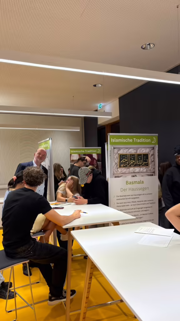 Jugendliche arbeiten an Tischen neben einem Banner der Wanderausstellung