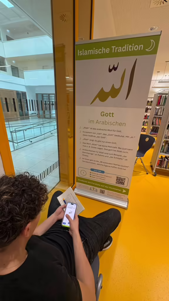 Schüler löst am Smartphone das Quiz vor einem Banner der islamischen Tradition