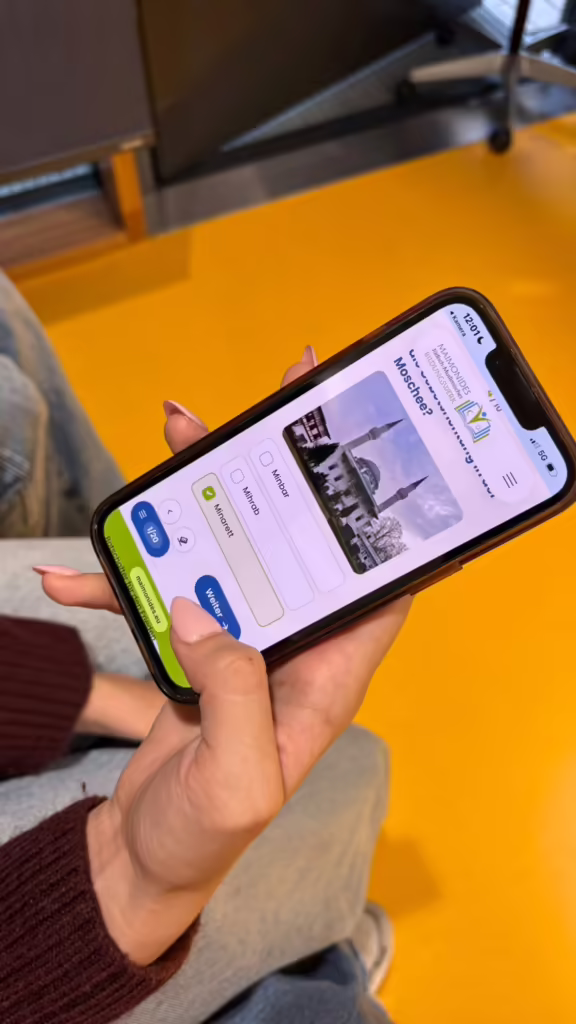 Smartphone mit dem Wanderausstellungsquiz in der Hand eines Schülers