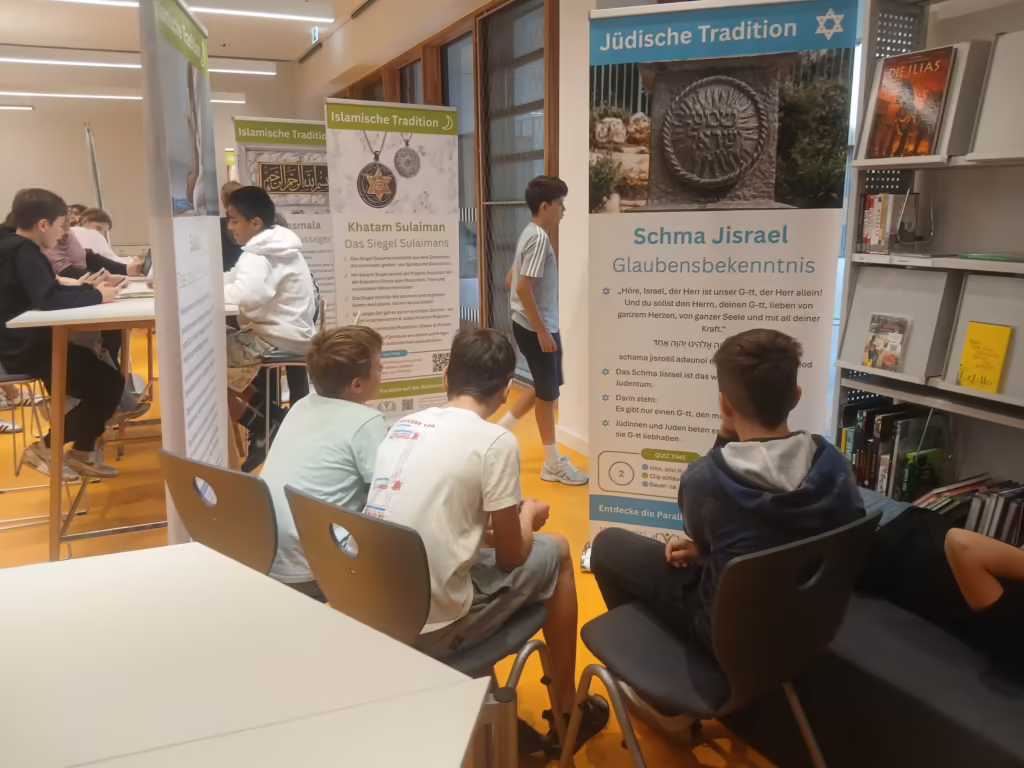 Klasse arbeitet an Tischen zwischen den Bannern der Wanderausstellung