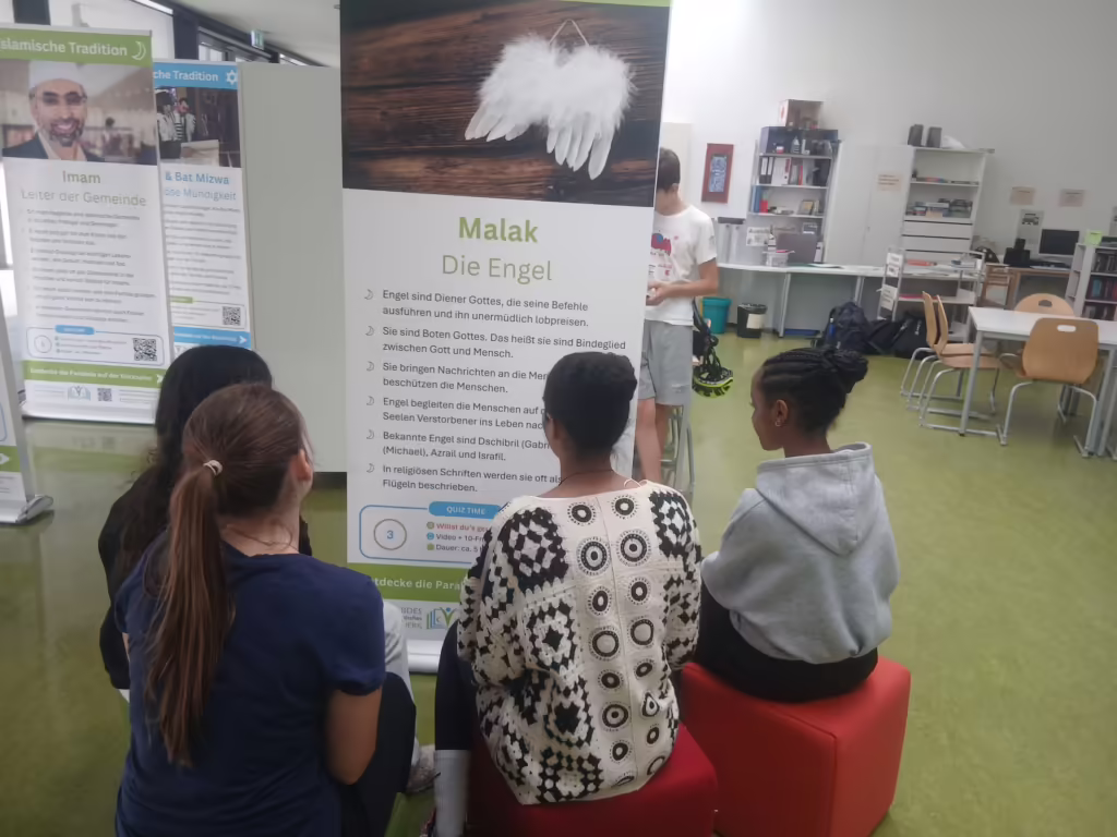 Jugendliche lesen gemeinsam ein Banner der Wanderausstellung