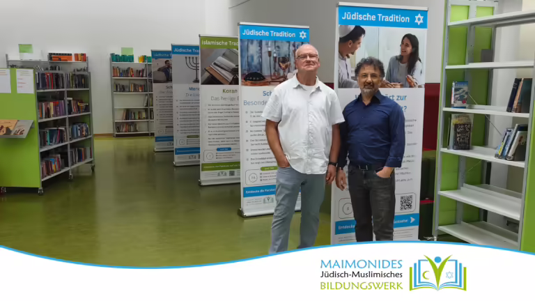 Die Maimonides-Geschäftsführer Mustafa Cimşit und Manfred Levy vor den Bannern der Wanderausstellung in der Bibliothek der Carlo-Mierendorff-Schule