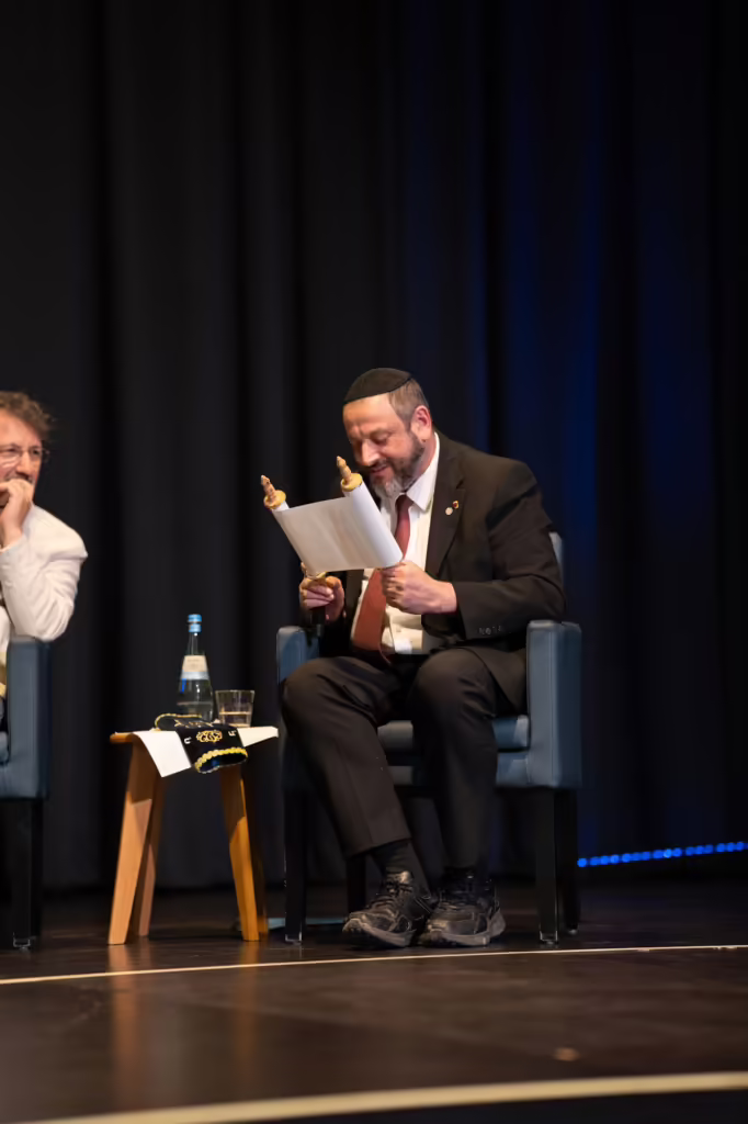 Ein Podiumsgast liest beim Ingelheimer Buber Diskurs aus seinen Notizen vor